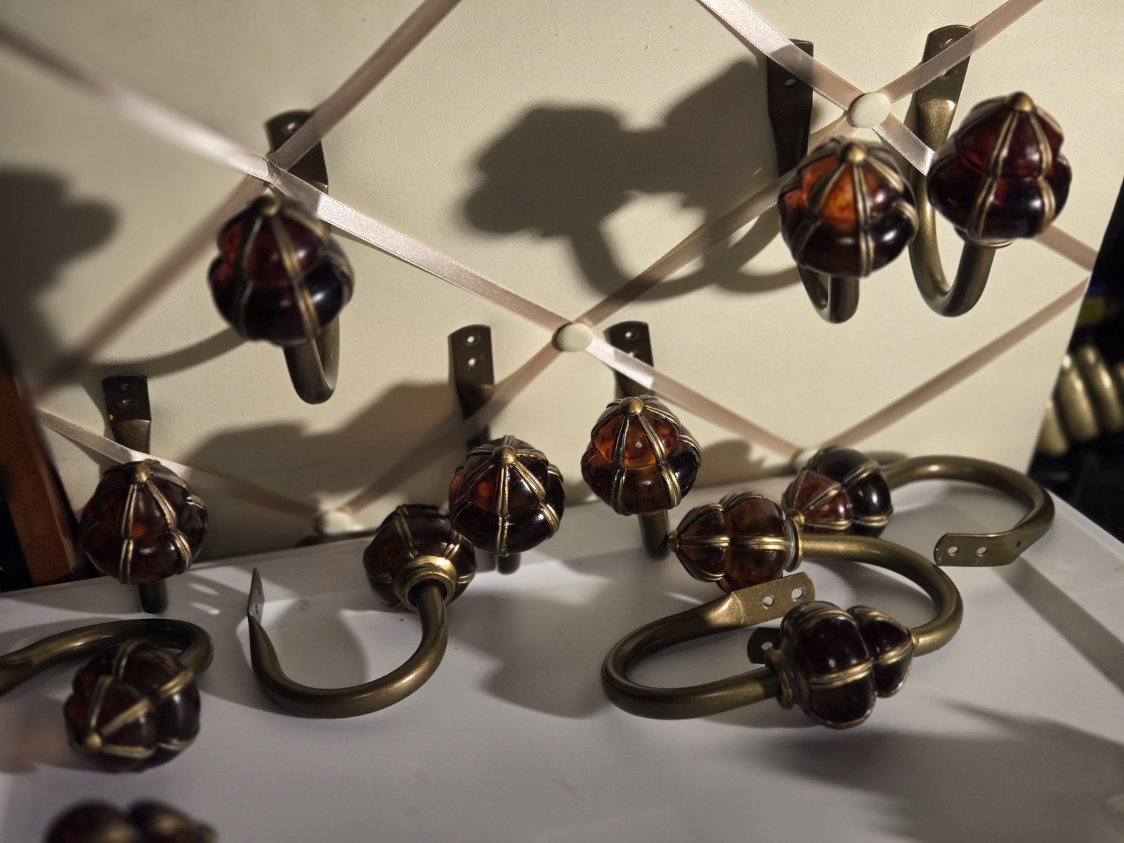decorative wall curtain tie-back orange knob and a brass-finished metal arm