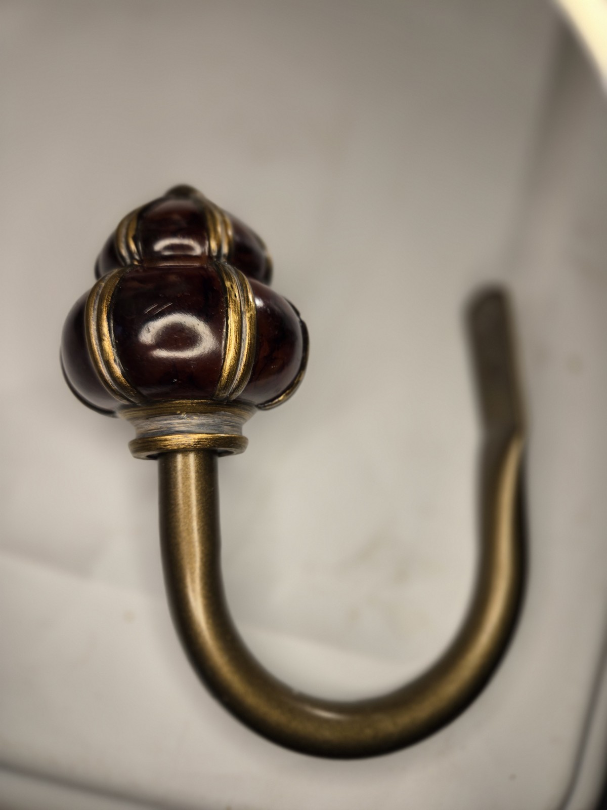 decorative wall curtain tie-back orange knob and a brass-finished metal arm
