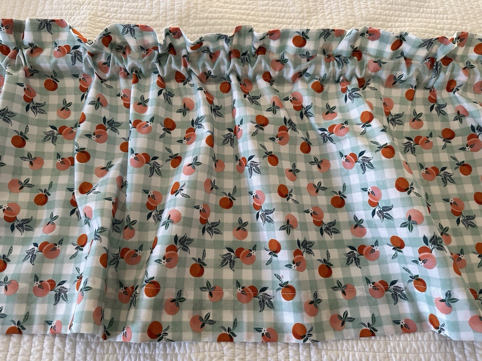 Small Checked Valance With Peaches. The Background Is A Green Blue Color. New