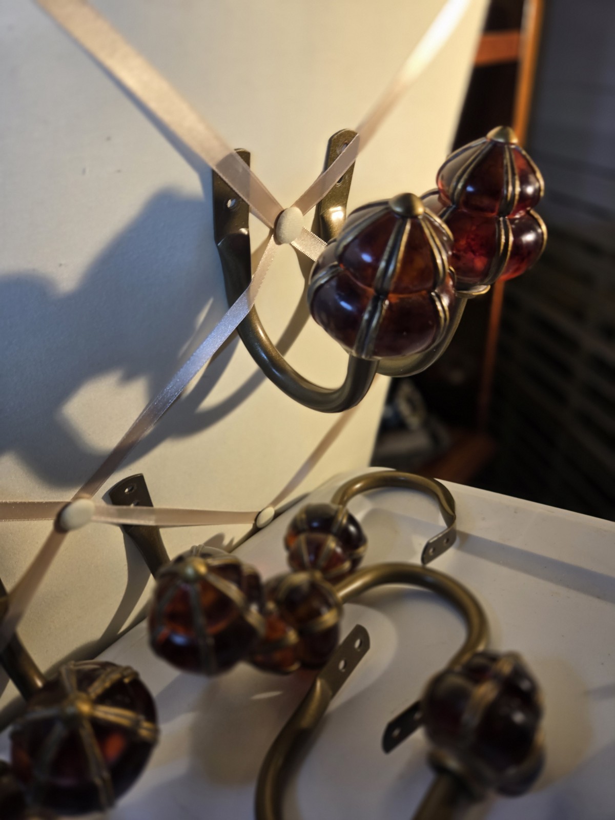 decorative wall curtain tie-back orange knob and a brass-finished metal arm