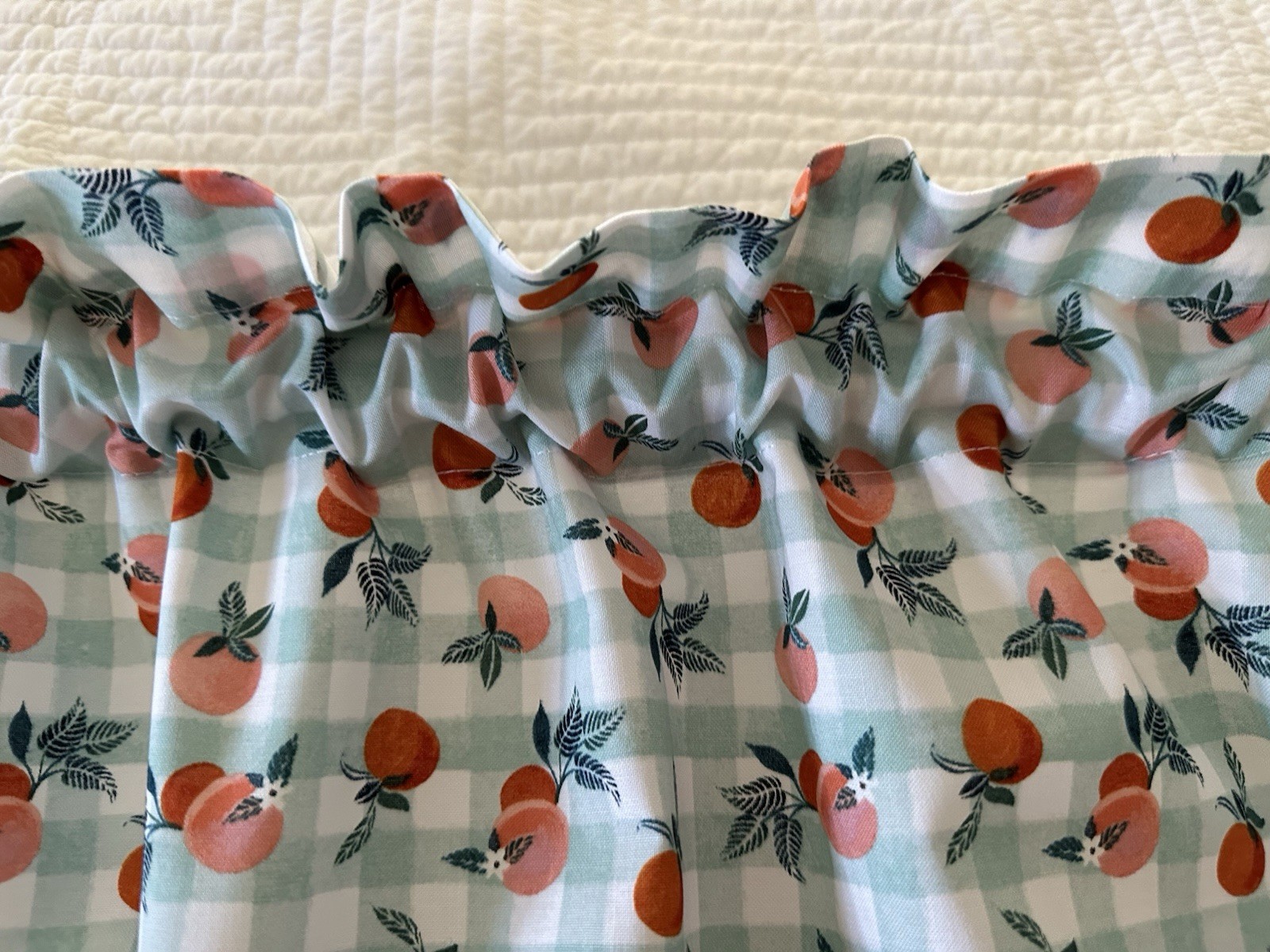 Small Checked Valance With Peaches. The Background Is A Green Blue Color. New