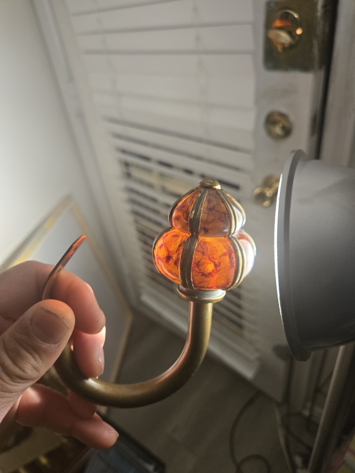 decorative wall curtain tie-back orange knob and a brass-finished metal arm