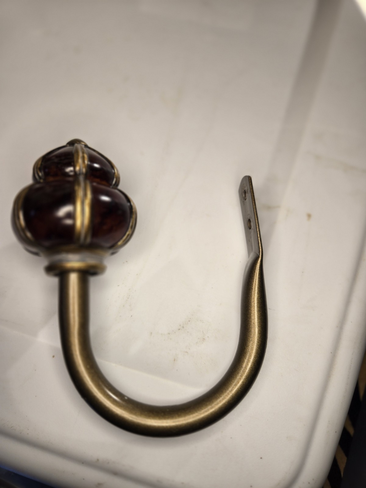decorative wall curtain tie-back orange knob and a brass-finished metal arm
